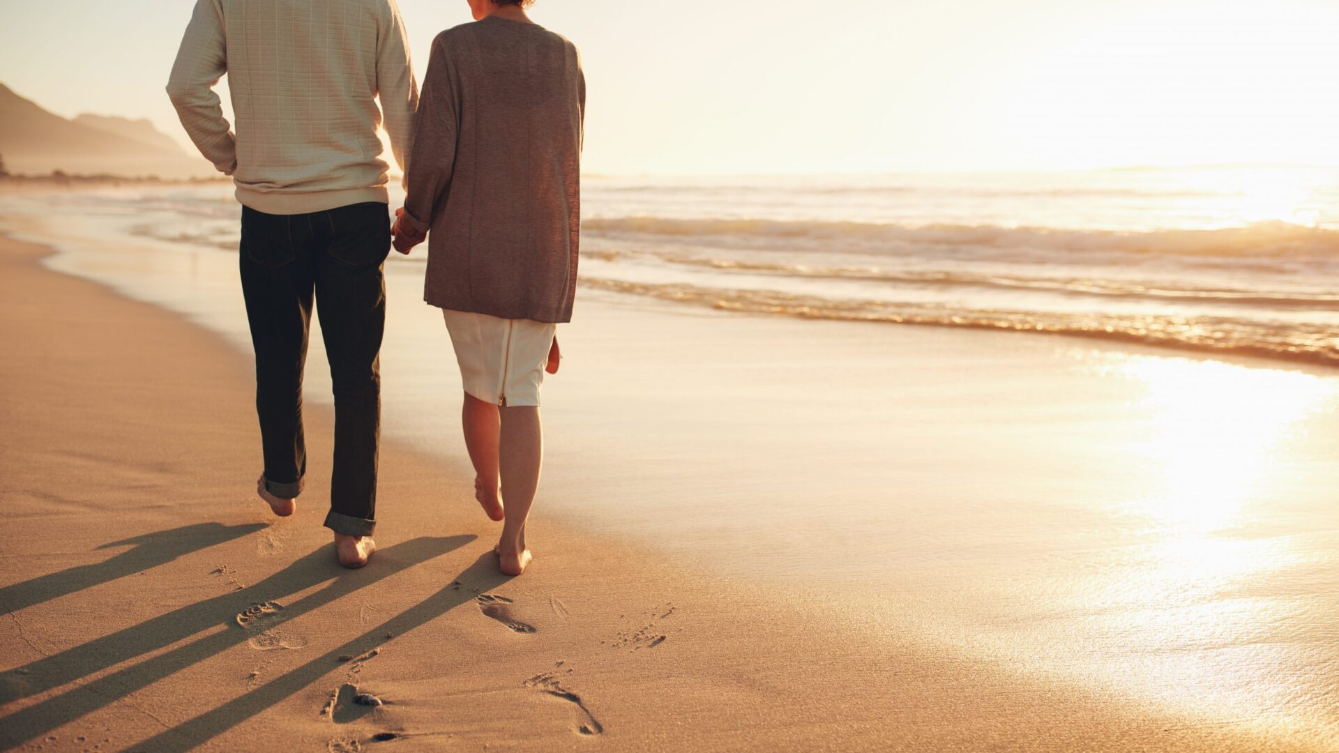 Retired couple walking along the beach