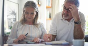 A middle-aged couple looking at notebooks